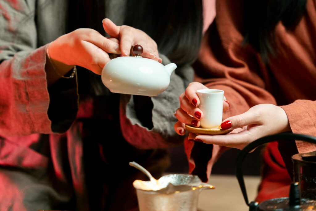 Close-up of a traditional tea ceremony with a focus on hands and tea tools, showcasing cultural details.